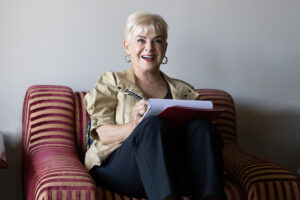 Mimi coaching a client sitting in striped chair